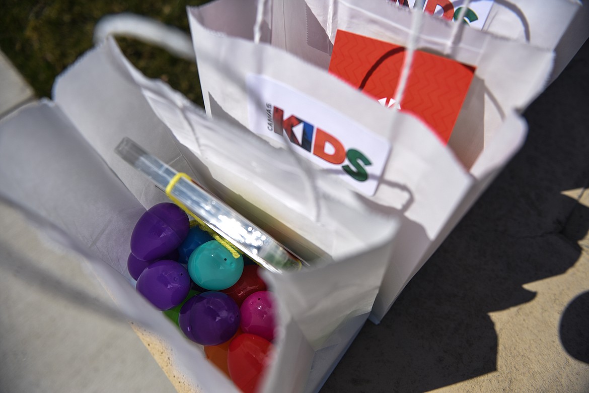Treat-filled plastic eggs, DVDs and other goodies were given out to families in the parking lot of Canvas Church in Kalispell on Thursday. The church filled over 1,000 bags with around 22,000 eggs for the Easter holiday. (Casey Kreider/Daily Inter Lake)
