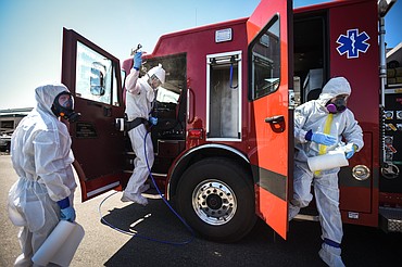 Workers with Dayspring Restoration sanitize a Kalispell Fire Department fire engine outside Murdoch’s Ranch & Home Supply in Kalispell on Thursday. Dayspring provided free, hospital-grade disinfection to any city and county vehicles from noon to 5 p.m. in response to the COVID-19 pandemic. (Casey Kreider/Daily Inter Lake)