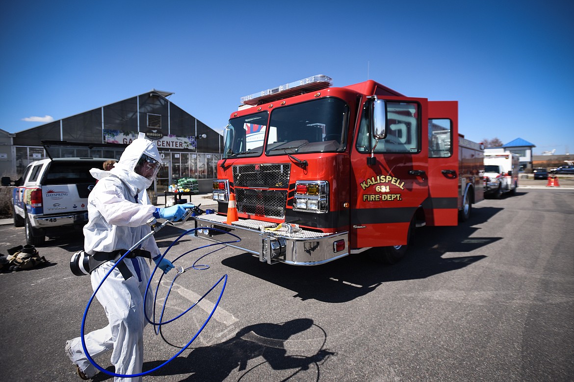 Workers with Dayspring Restoration sanitize a Kalispell Fire Department fire engine outside Murdoch’s Ranch & Home Supply in Kalispell on Thursday. Dayspring provided free, hospital-grade disinfection to any city and county vehicles from noon to 5 p.m. in response to the COVID-19 pandemic. (Casey Kreider/Daily Inter Lake)