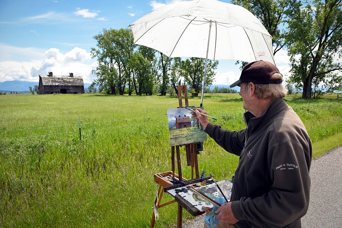 Artist Mark Ogle works on a plein air painting of the Porter/Blasdel Barn along North Somers Road on Thursday, June 18. Ogle, the owner of Mark Ogle Studio in Kalispell, is one of 52 artists creating works for the Hockaday Museum of Art's Plein Air Glacier 2020: Paint Out. The resulting artwork will be sold during an online auction from 5 to 8 p.m. Saturday, June 27. A selection of works will be on view at the museum and a preview is available on the Hockaday's website at hockadaymuseum.org. (Casey Kreider/Daily Inter Lake)