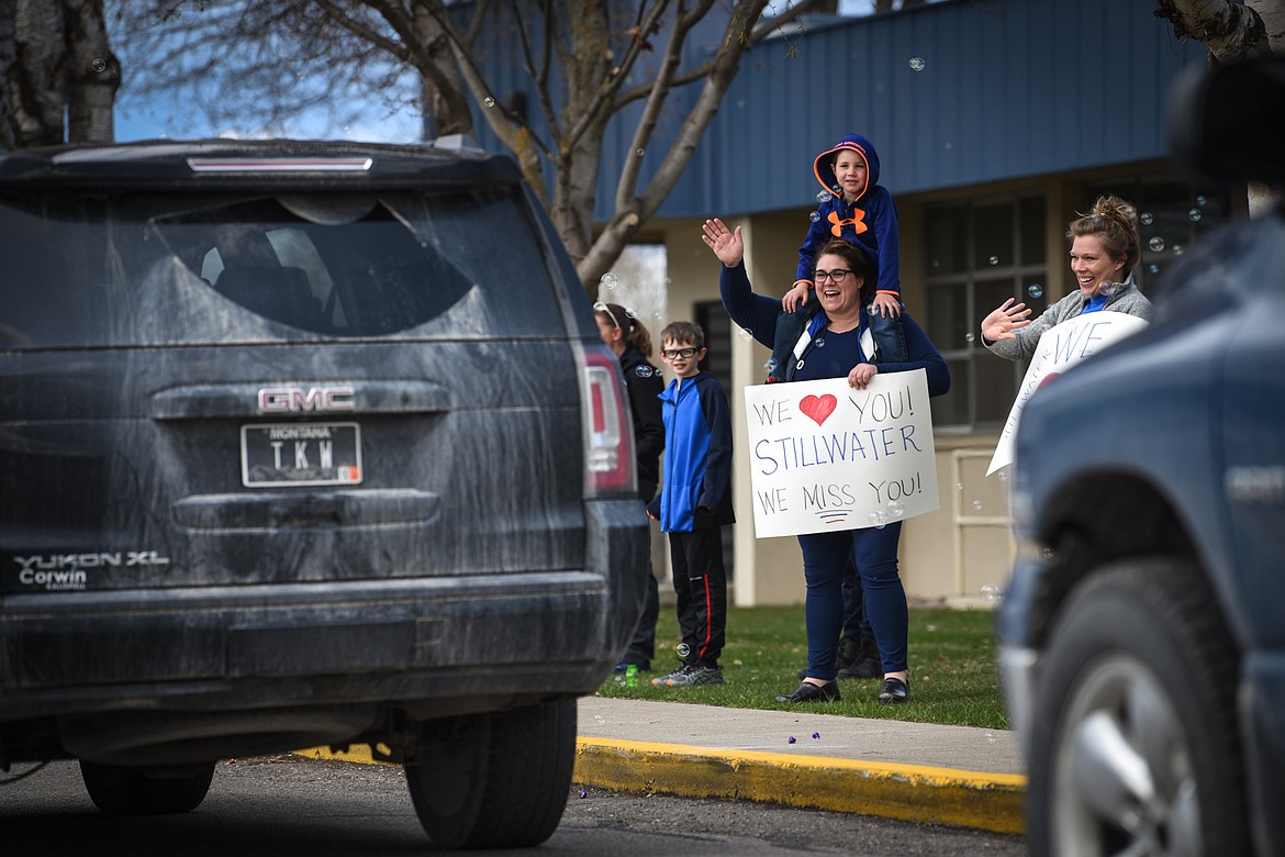 Stillwater Christian School fourth-grade teacher Rya Diede and her son Cal wave to students and parents during a parade for grades K-5 outside the school on Friday, April 24. (Casey Kreider/Daily Inter Lake)