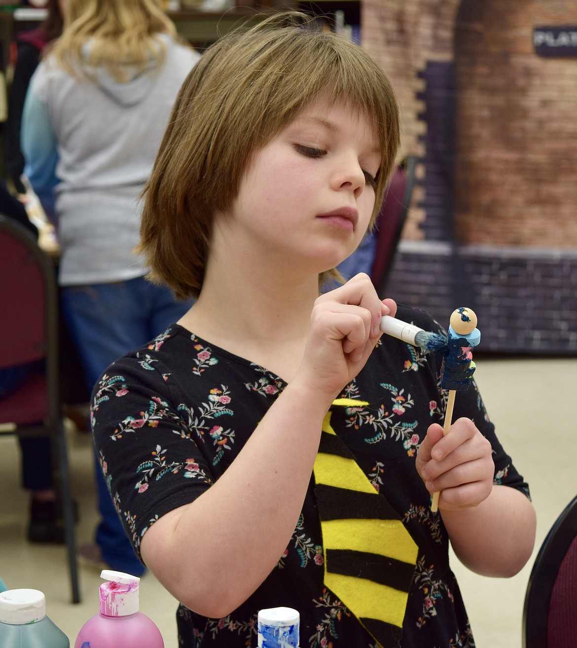 A girl in a felt Hufflepuff tie paints a magic wand at the Moses Lake Public Library on Friday.