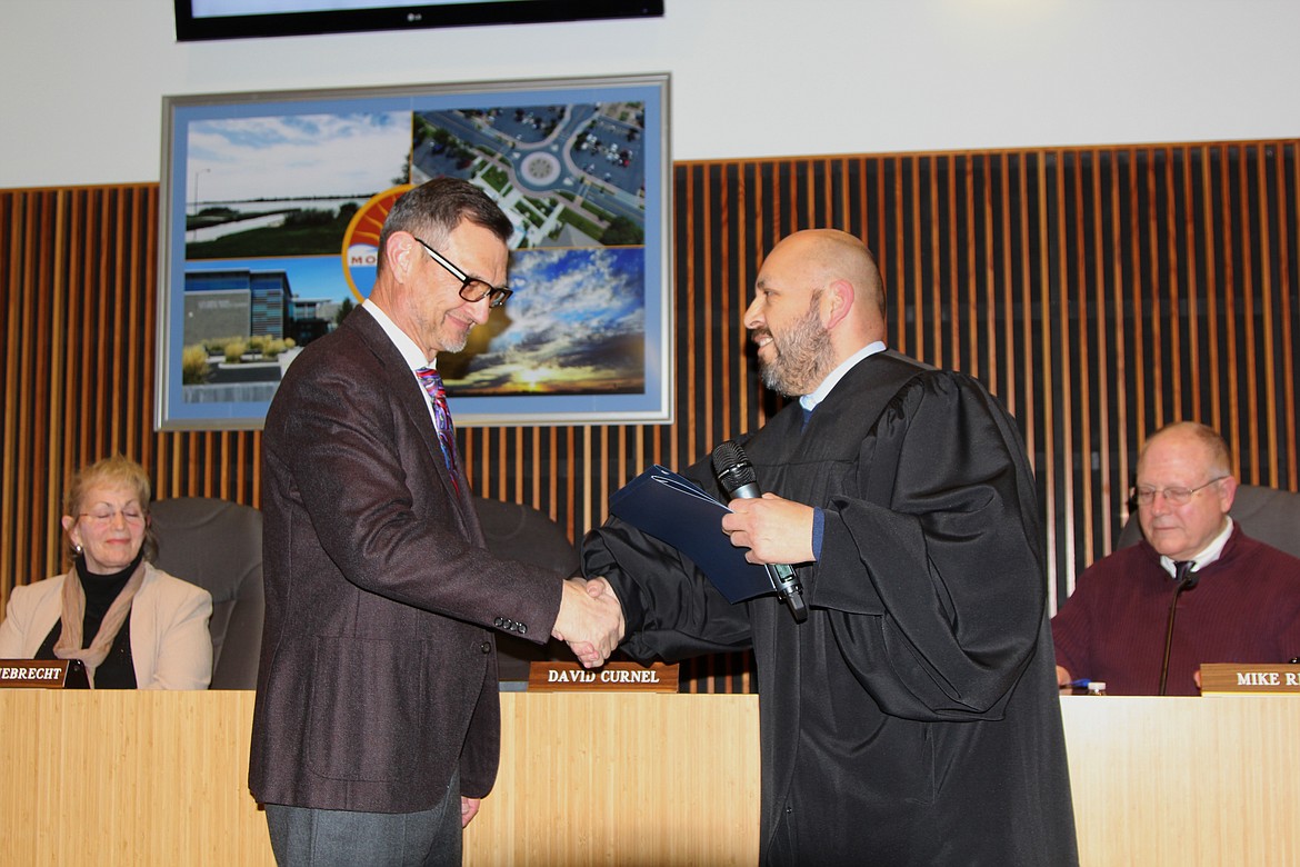 Newly-elected Mayor David Curnel shakes hands with Judge David Estudillo, having just been sworn in to his new position as the ceremonial leader of Moses Lake.