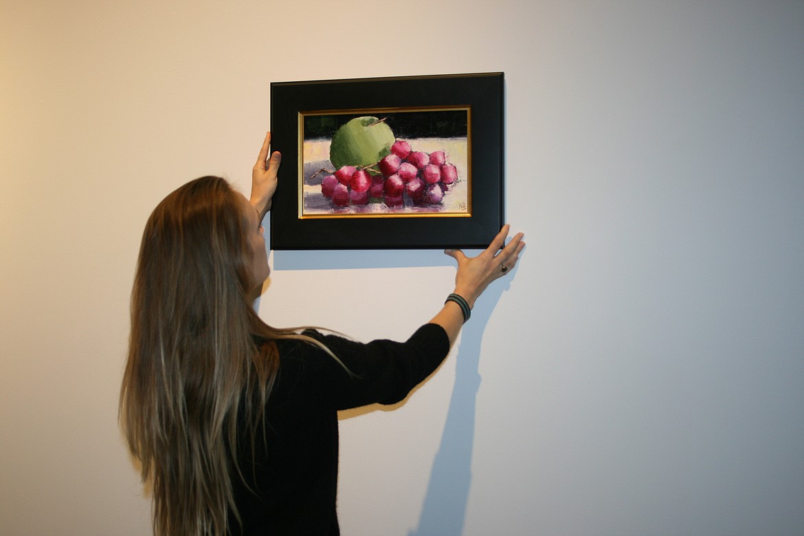 Moses Lake Museum & Art Center artistic director Erika Kovalenko experiments with a possible design for the “Uncorked” exhibit opening Friday at the museum.