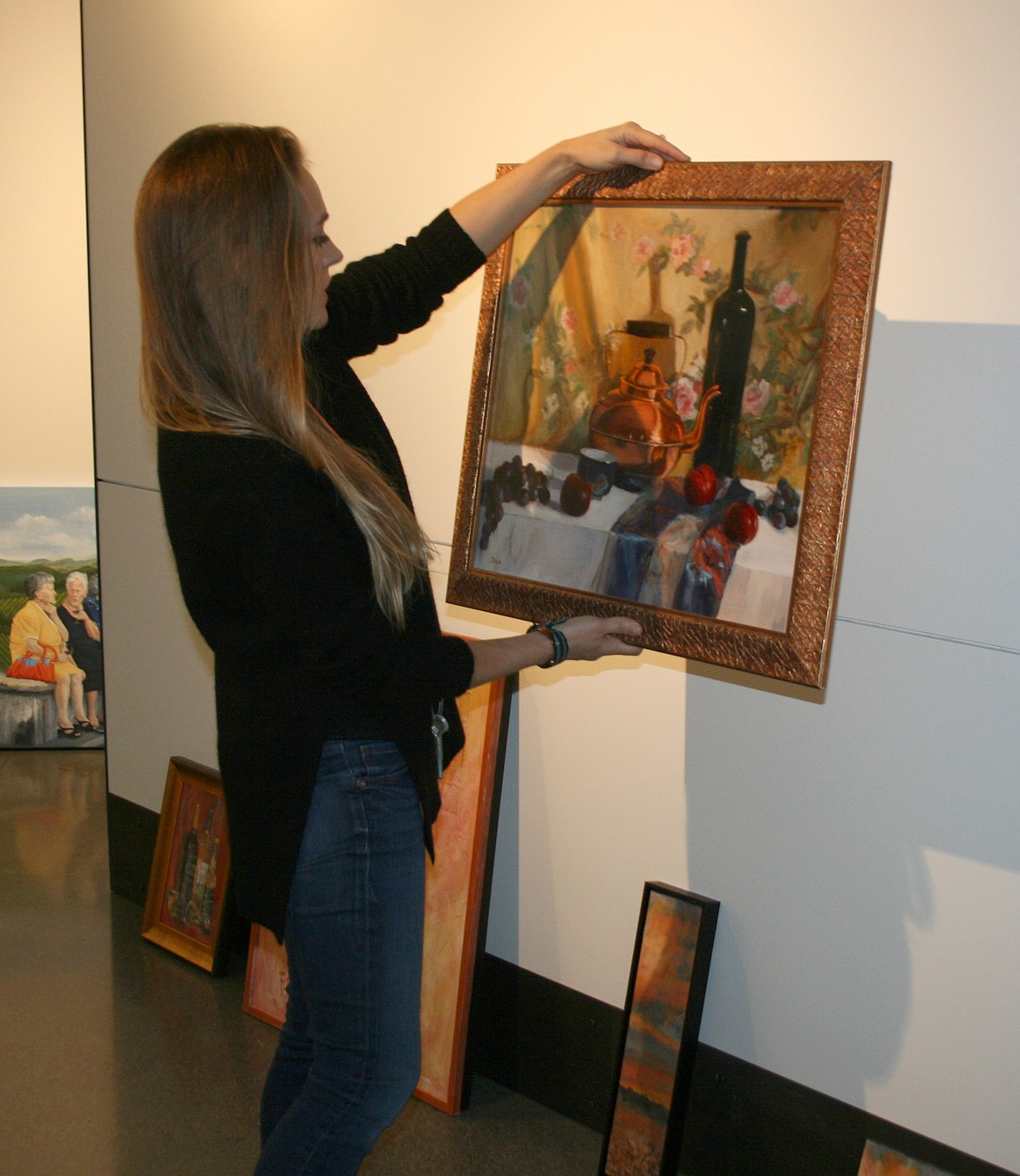 Erika Kovalenko checks her options for installation of the “Uncorked” group art show opening Friday at the Moses Lake Museum & Art Center. Kovalenko is the museum’s artistic director.