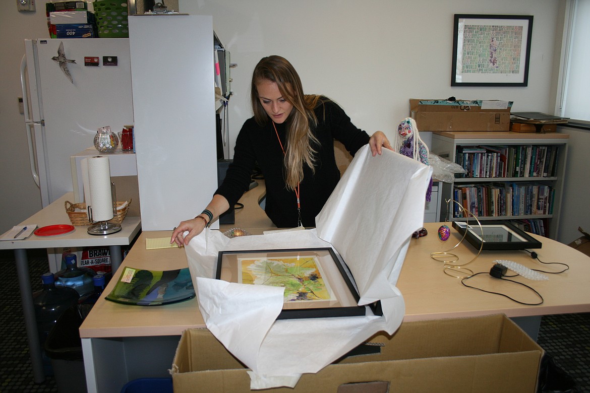 Erika Kovalenko, artistic director at Moses Lake Museum & Art Center, unpacks artworks destined for the “Uncorked” exhibit opening Friday.