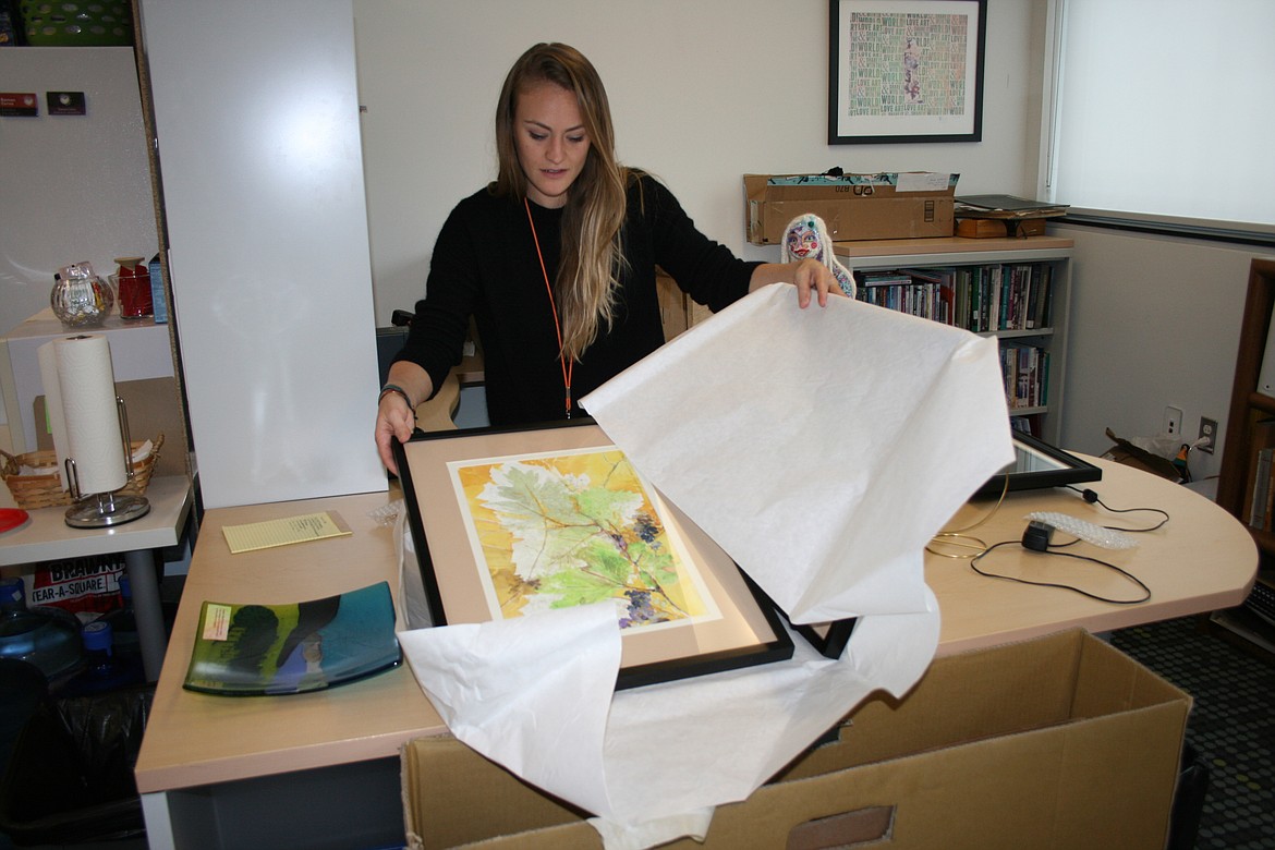 Erika Kovalenko, artistic director at Moses Lake Museum & Art Center, unpacks artworks destined for the “Uncorked” exhibit opening Friday.