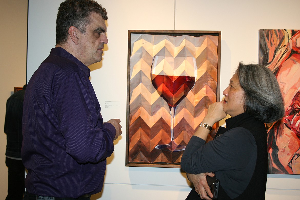 Cheryl Schweizer/Columbia Basin Herald 
 Seattle artist Kelly Paik talks with a gallery patron during opening of the "Uncorked" exhibit at the Moses Lake Museum & Art Center Friday.