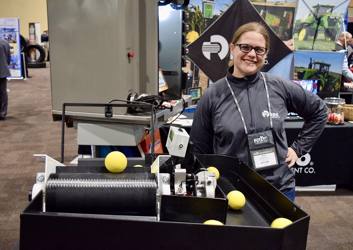 Erin Hightower, an agronomist for RDO Equipment, shows off a special Greentronics conveyor belt that weighs crops like potatoes as they are harvested at the Washington-Oregon Potato Conference in Kennewick Wednesday. When combined with GPS data, Hightower said the system, sold by RDO, allows farmers to know precisely how much they harvest and where.