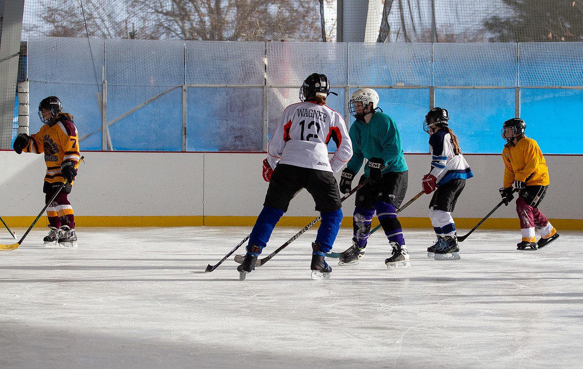 Skaters along the ice at the Moses Lake Ice Rink work on skating and hockey drills at the Play Hockey Like a Girl event on Monday morning.