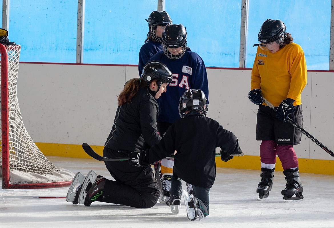 USA Hockey coach Rachel Applebaum helps a young woman with her skates at the Moses Lake Ice Rink on Monday. Applebaum helped instruct drills and scrimmages at the Play Hockey Like a Girl event in its second year.