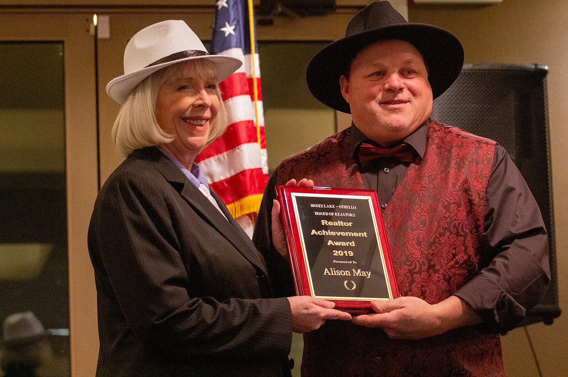 Casey McCarthy/Columbia Basin Herald | Outgoing President Doug Robins presents Alison May with the Realtor Achievement Award for the year at the Association’s annual banquet on Saturday.