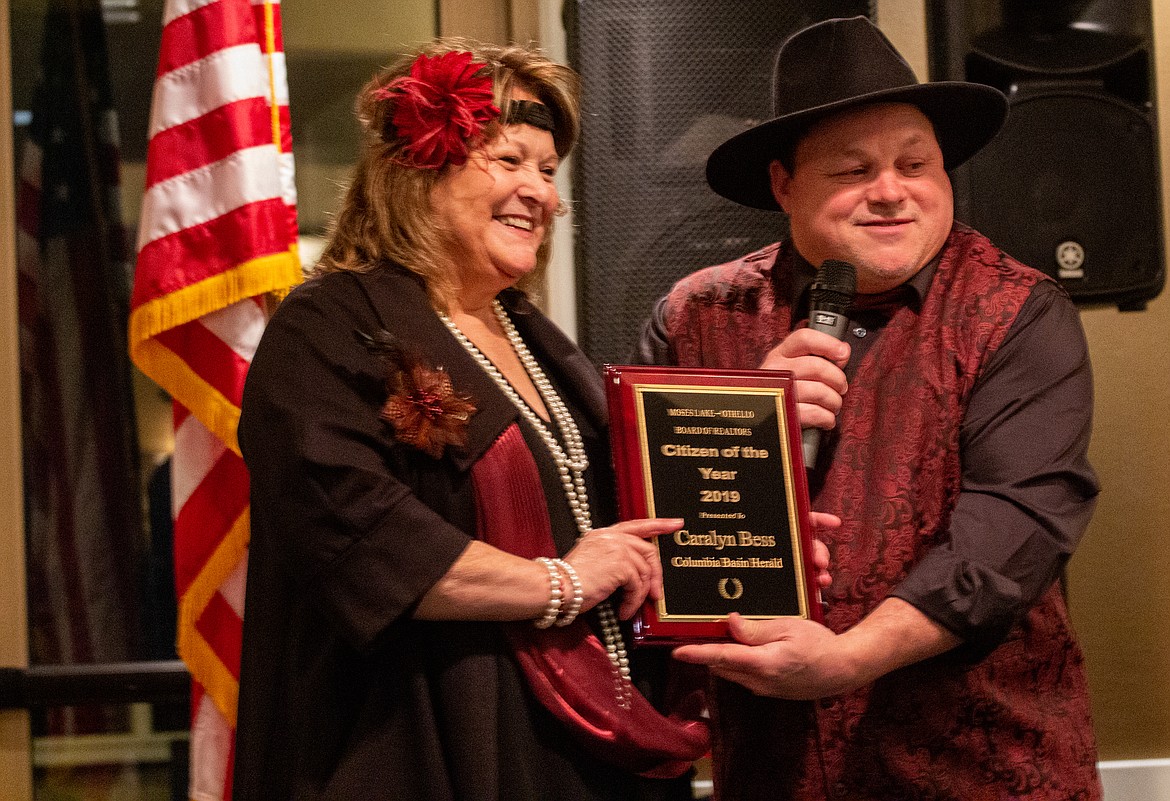 Caralyn Bess, publisher of the Columbia Basin Herald, is presented the Citizen of the Year Award by Doug Robins, outgoing president of the Moses Lake-Othello Association of Realtors, on Saturday night.