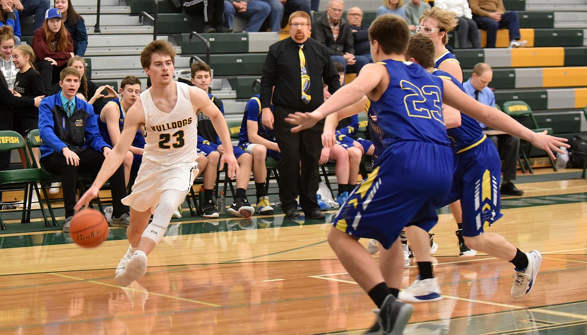 Bulldog Justin Conklin dribbles the ball Friday night against the Libby Loggers at the Whitefish High School gym. (Heidi Desch/Whitefish Pilot)