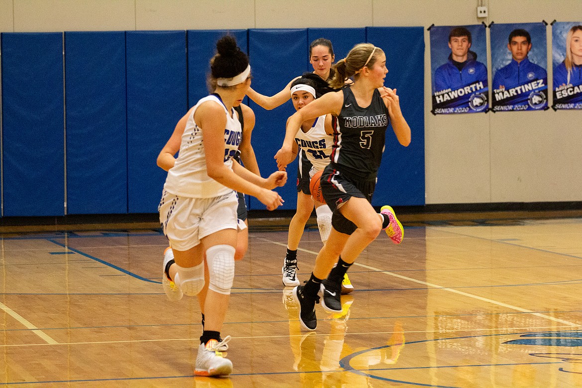 Casey McCarthy/Columbia Basin Herald Jlynn Rios locks eyes with her sister, Kiana, as they push the ball on the fast break on Tuesday night against Cascade.