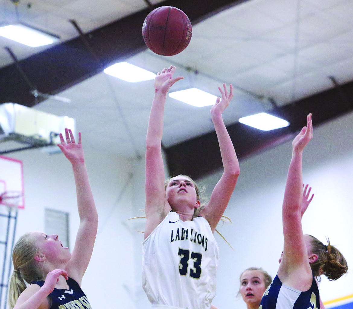 Connor Vanderweyst/Columbia Basin Herald 
 Moses Lake Christian's Kali Kast (33) shoots between two Riverside Christian defenders.