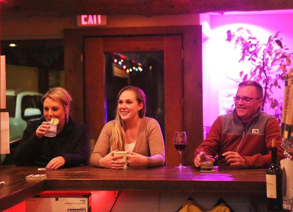 Three speed-dating participants wait at the bar for the evening’s activities to begin.