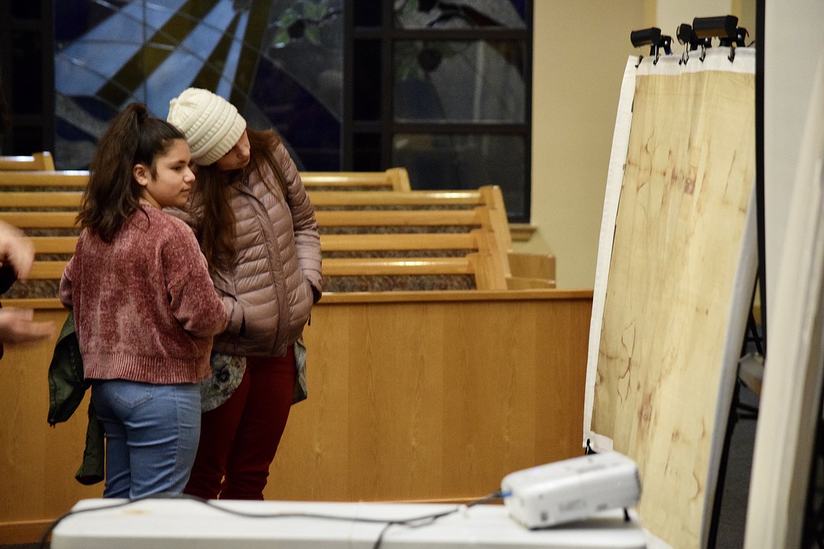 Charles H. Featherstone/Columbia Basin Herald 
 A pair of young women examine a life-sized image of the Shroud of Turin.