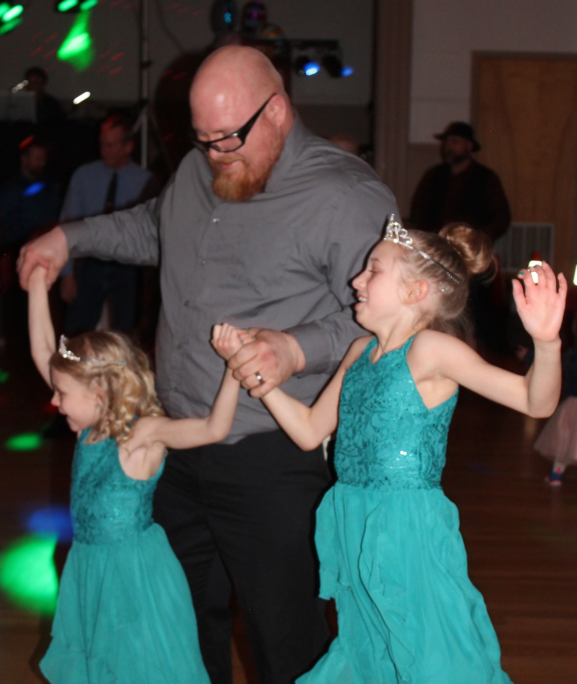 Jeremy Block tries to keep up with his dance partners Kaydence, 10, right, and Matteha, 7, at the Daddy-Daughter Dance in Ephrata Saturday night.