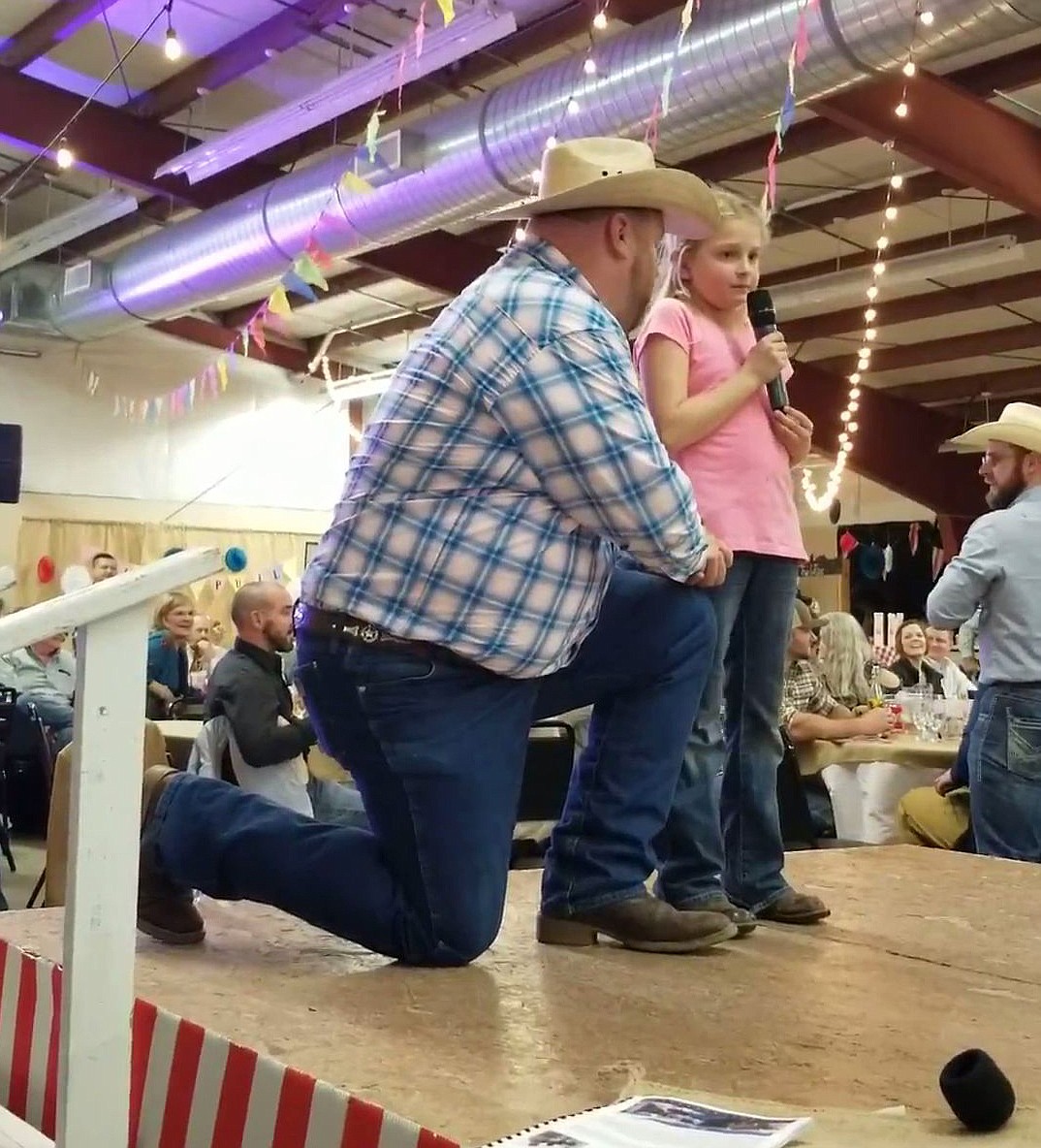 Auctioneer Chuck Yarbro, left, helps 9-year-old Rebecca Wiser raise money at the Columbia Basin Cancer Foundation’s Country Sweethearts auction Feb. 1.