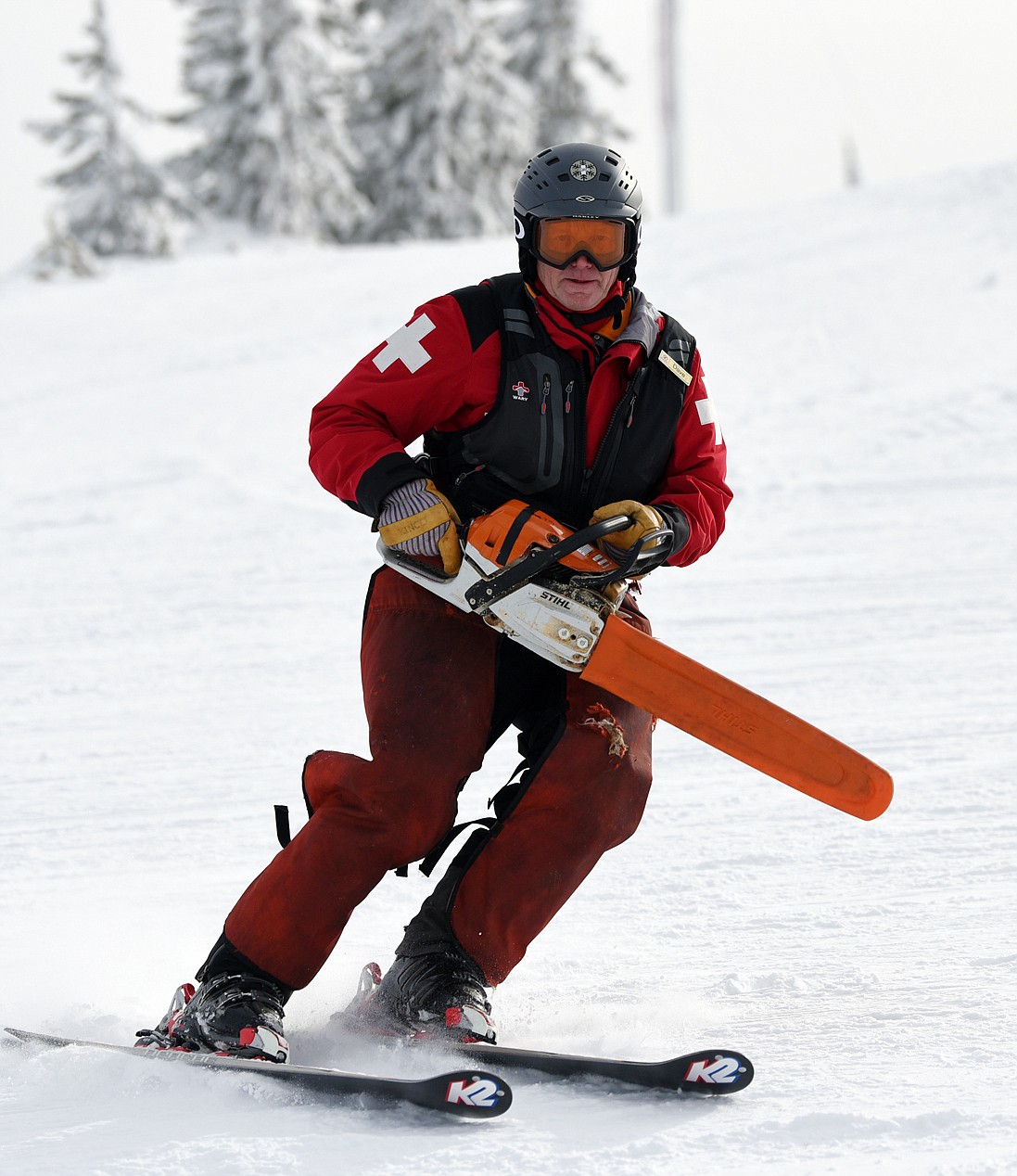 Ski patroller Dave Filler totes a chainsaw as he heads down a run to perform some tree work at Blacktail Mountain Ski Area.