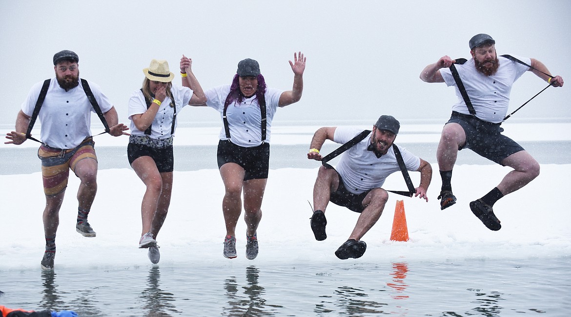 Members of the National Parks Realty team jump into Whitefish Lake Saturday morning during the annual Penguin Plunge at City Beach. The event raises money for Special Olympics Montana. (Heidi Desch/Whitefish Pilot)