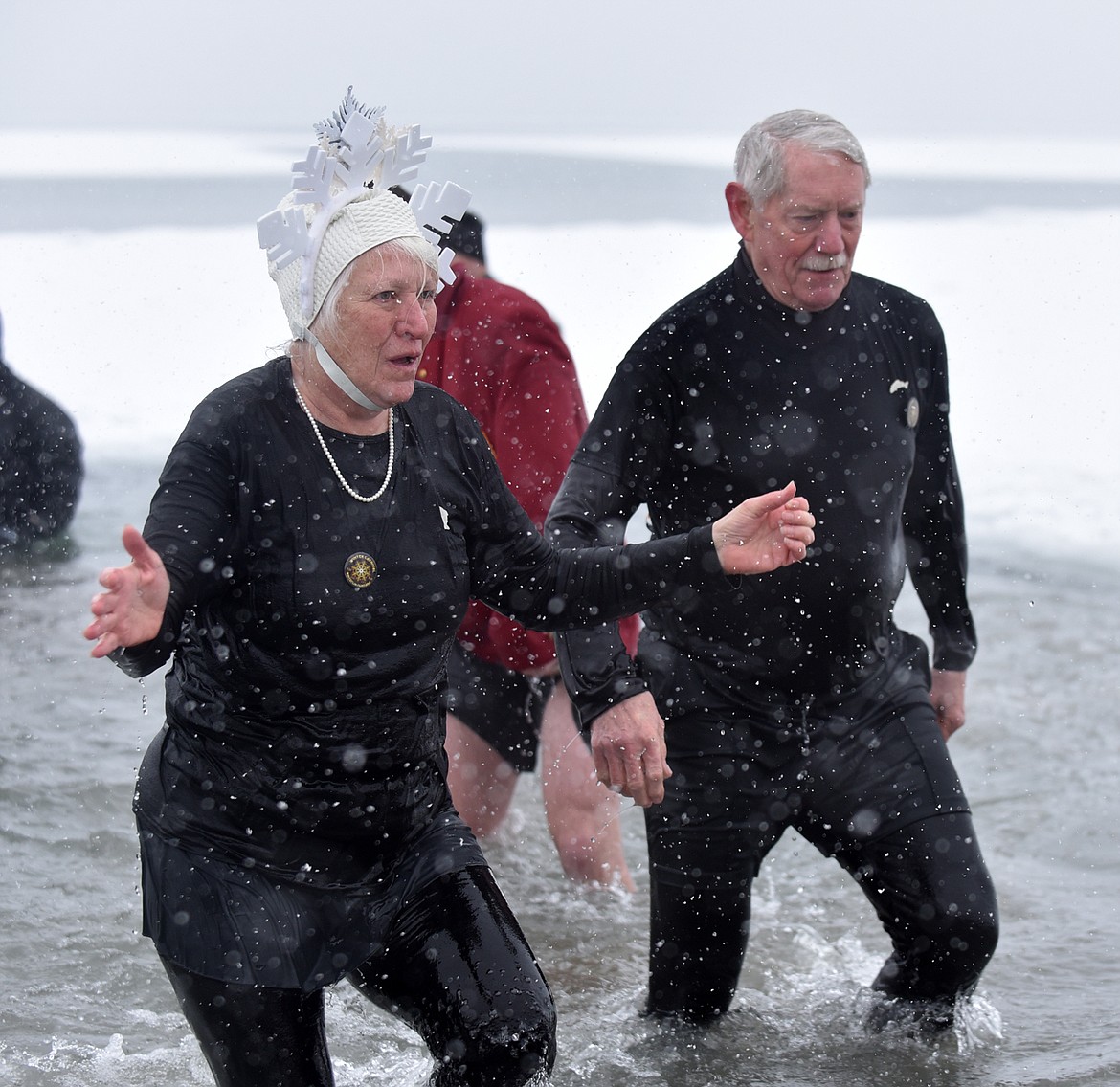 Queen of Snows Gayle MacLaren and King Ullr Scotty MacLaren emerge from Whitefish Lake Saturday morning during the annual Penguin Plunge at City Beach. (Heidi Desch/Whitefish Pilot)