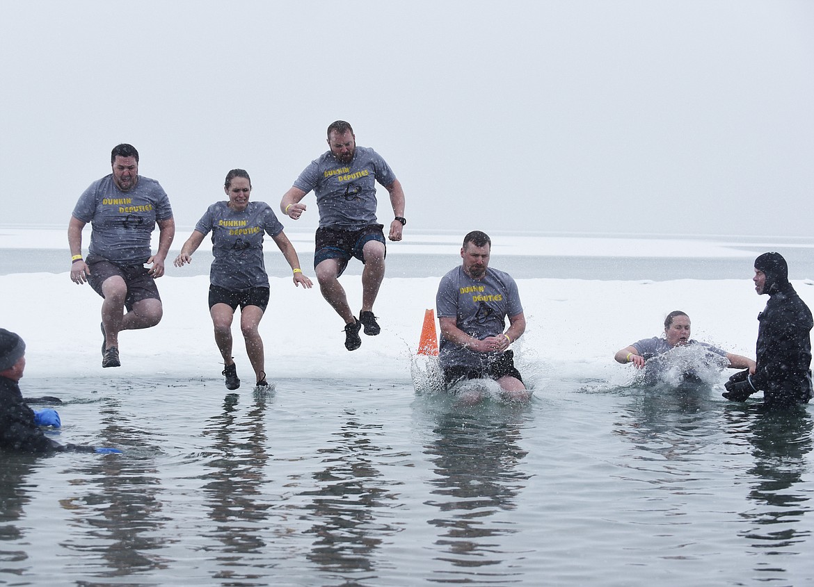 A group from the Flathead County Sheriff’s Office jumps into Whitefish Lake Saturday morning during the annual Penguin Plunge at City Beach. The event raises money for Special Olympics Montana. (Heidi Desch/Whitefish Pilot)