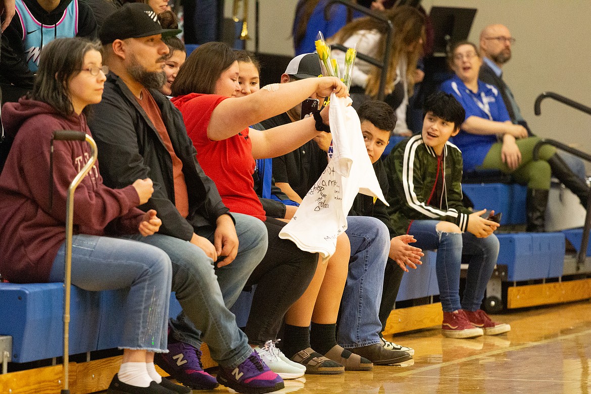 Avree Pruneda smiles as she’s presented with a shirt, signed with messages of support by the Warden boys basketball team, before their game against Kiona-Benton on Jan. 21.