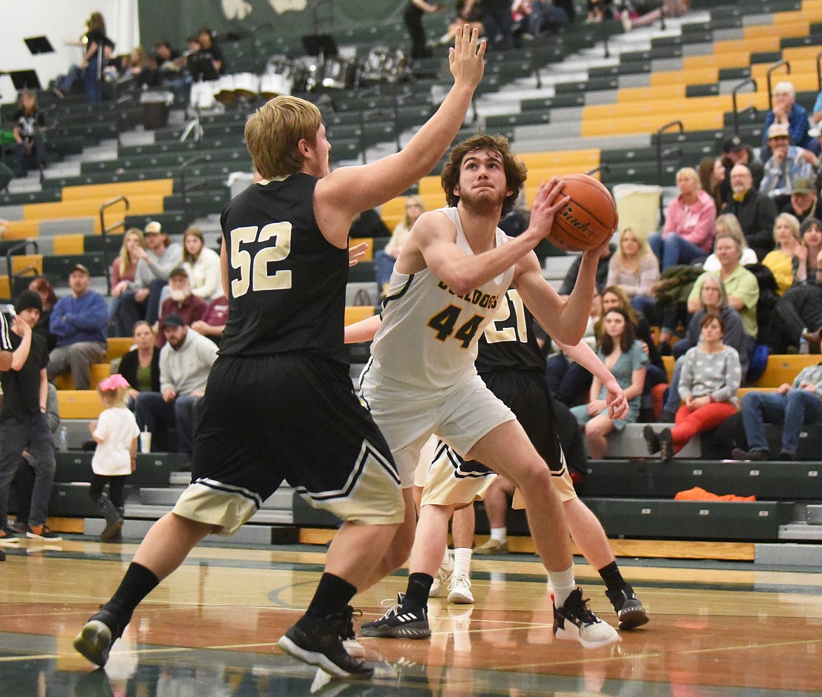 Sam Menicke posts up a pair of Yellowjacket defenders during Friday’s home battle against Stevensville. (Daniel McKay/Whitefish Pilot)