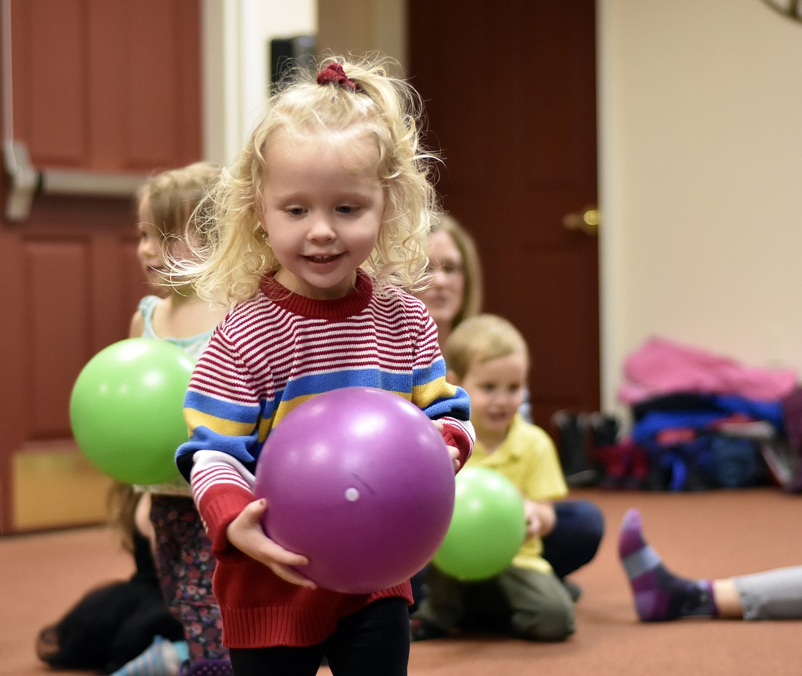 Landry Platt, 2, picks up a ball during North Valley Music School’s Music Together class at The Springs at Whitefish on Wednesday afternoon. (Heidi Desch/Whitefish Pilot)