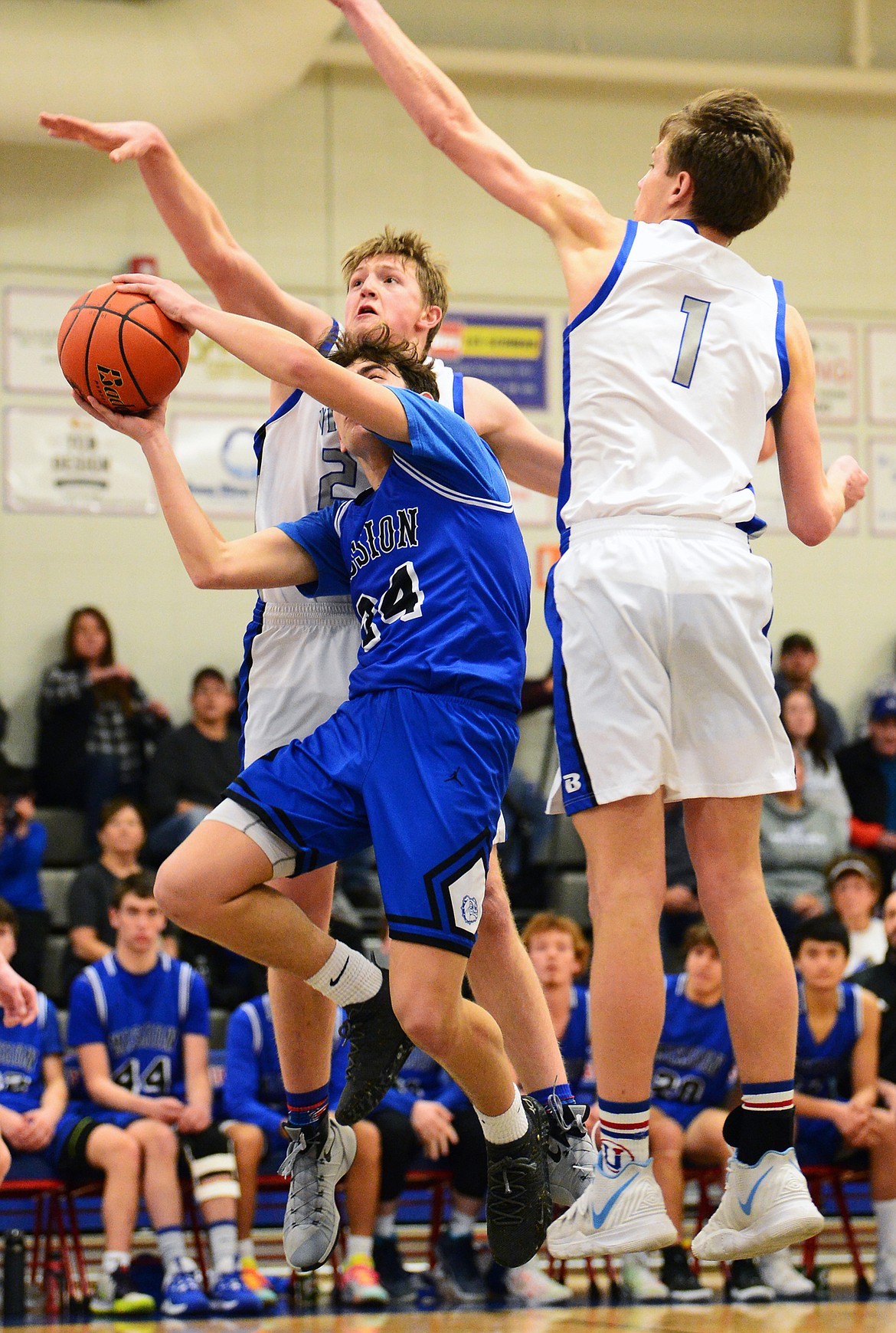 Mission’s Jedi Christy (24) drives to the basket against Bigfork’s Isaac Bjorge (23) and Colt Thorness (1) at Bigfork High School on Thursday. (Casey Kreider/Daily Inter Lake)