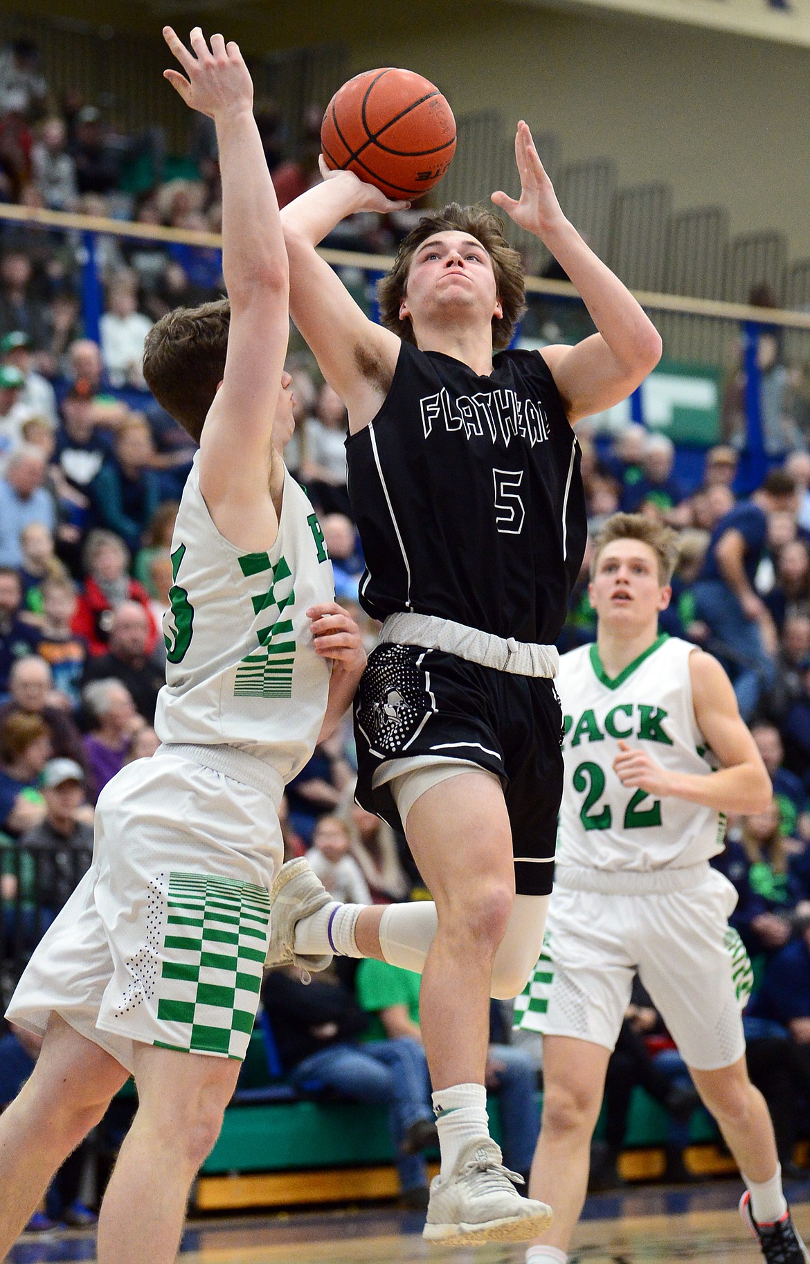 Flathead's Tannen Beyl (5) drives to the hoop against Glacier's Drew Engellant (15) during a crosstown matchup at Glacier High School on Friday. (Casey Kreider/Daily Inter Lake)