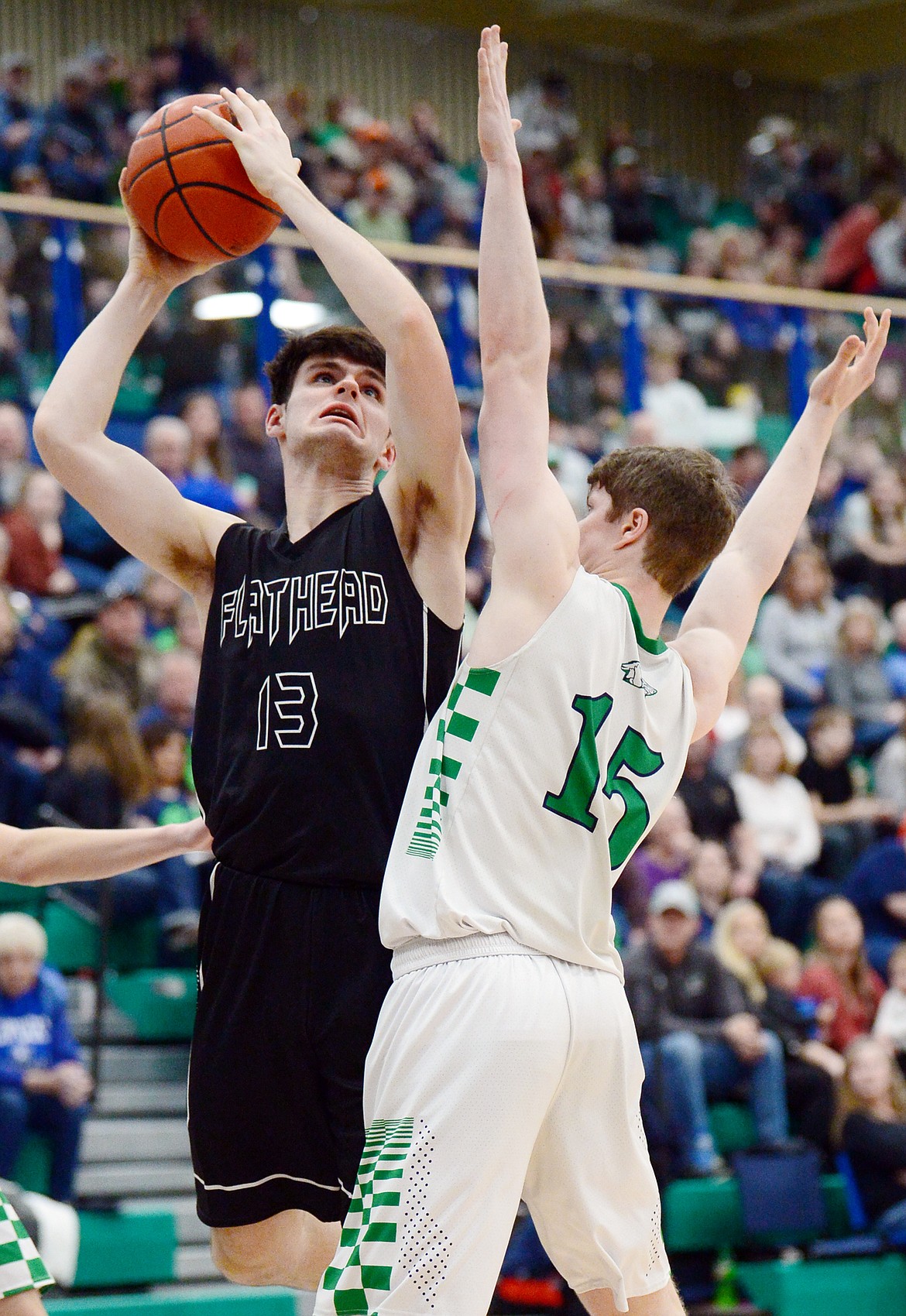 Flathead's Gabe Adams (13) looks to shoot over Glacier's Drew Engellant (15) during a crosstown matchup at Glacier High School on Friday. (Casey Kreider/Daily Inter Lake)