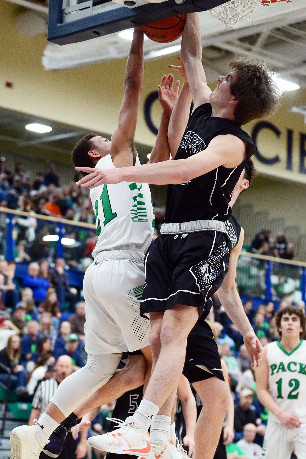 Flathead's Cooper Smith (20) and Gabe Adams (13) block a layup attempt by Glacier's Anthony Heath (21) during a crosstown matchup at Glacier High School on Friday. (Casey Kreider/Daily Inter Lake)