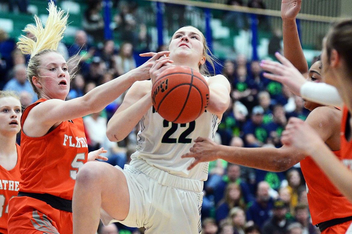Glacier's Ellie Keller (22) is fouled on her way to the hoop by Flathead's Maddy Moy (5) during a crosstown matchup at Glacier High School on Friday. (Casey Kreider/Daily Inter Lake)