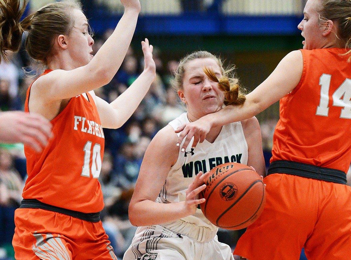 Glacier's Ellie Keller (22) drives to the hoop between Flathead's Kennedy Kanter (10) and Jenna Johnson (14) during a crosstown matchup at Glacier High School on Friday. (Casey Kreider/Daily Inter Lake)