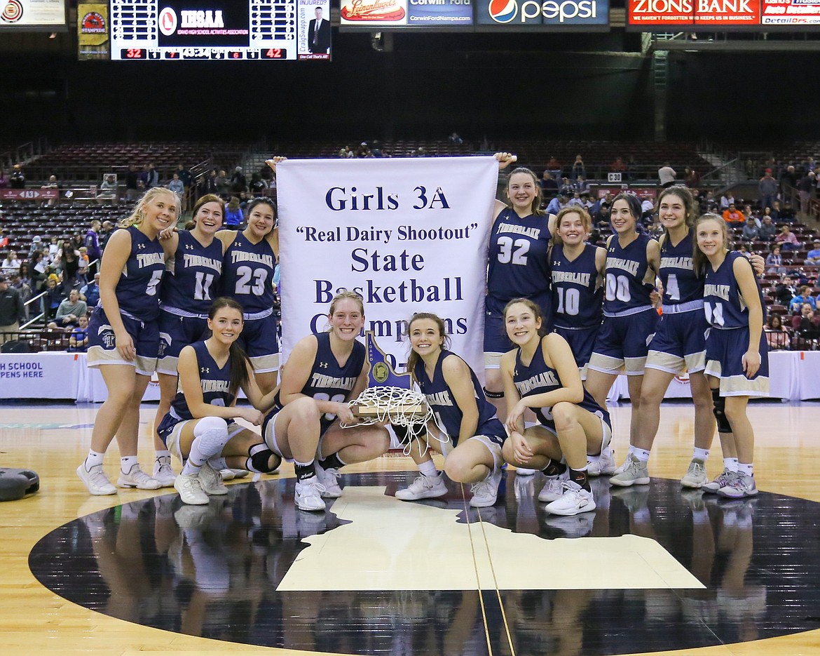Photo by JASON DUCHOW PHOTOGRAPHY
Timberlake High’s girls basketball team poses with the trophy and the banner after defeating Snake River 42-32 in the championship game of the state 3A girls basketb