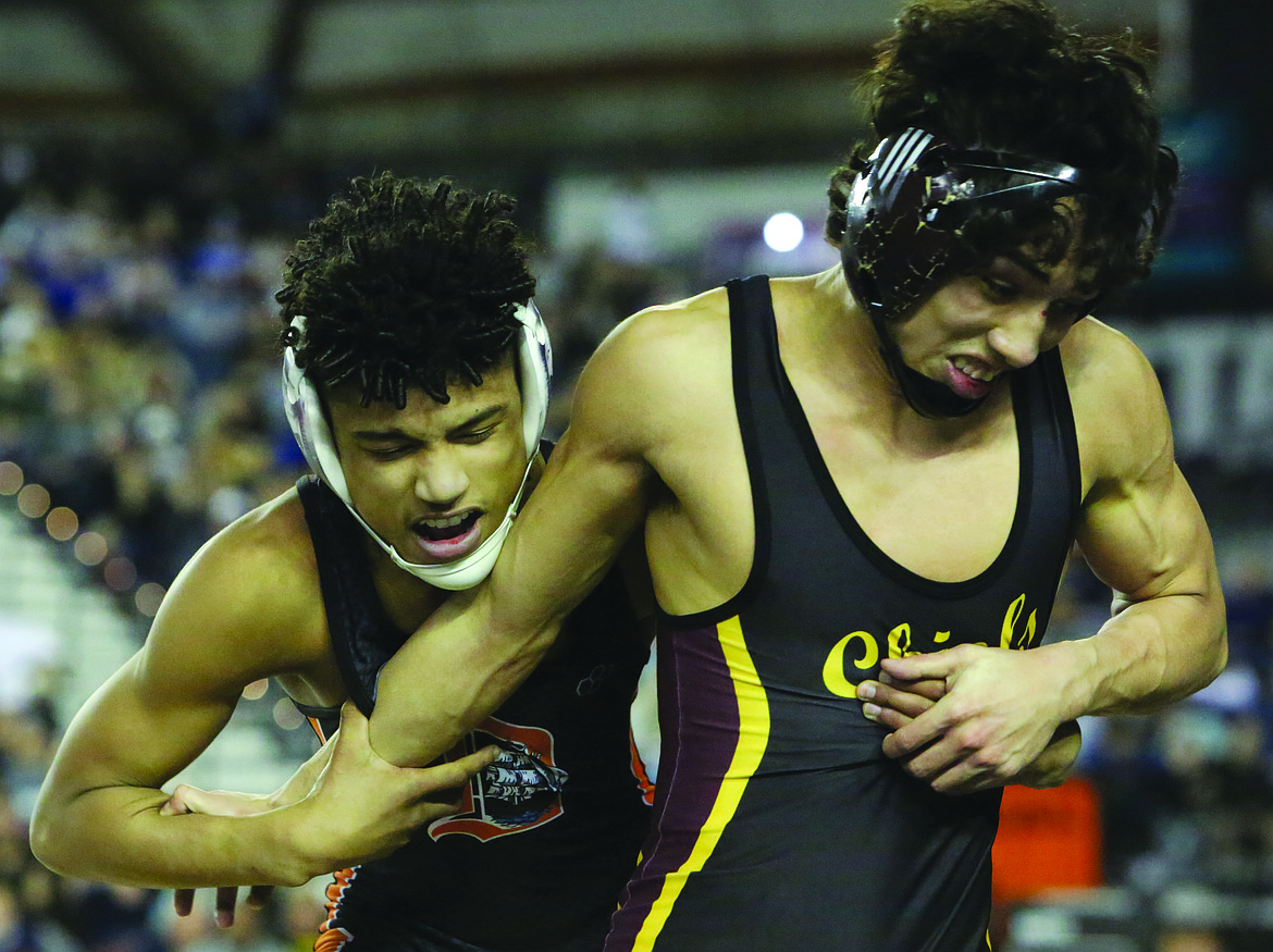 Connor Vanderweyst/Columbia Basin Herald 
 Moses Lake's Jonathan Tanguma (right) looks to free himself from the grasp of Davis' Jaden Sanchez during the 113-pound state finals.