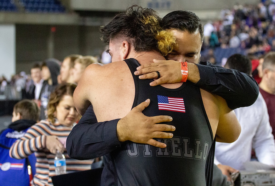 Casey McCarthy/Columbia Basin Herald Isaiah Perez and Othello head coach Rudy Ochoa II embrace after the senior claimed his third title on Saturday evening in the Tacoma Dome.