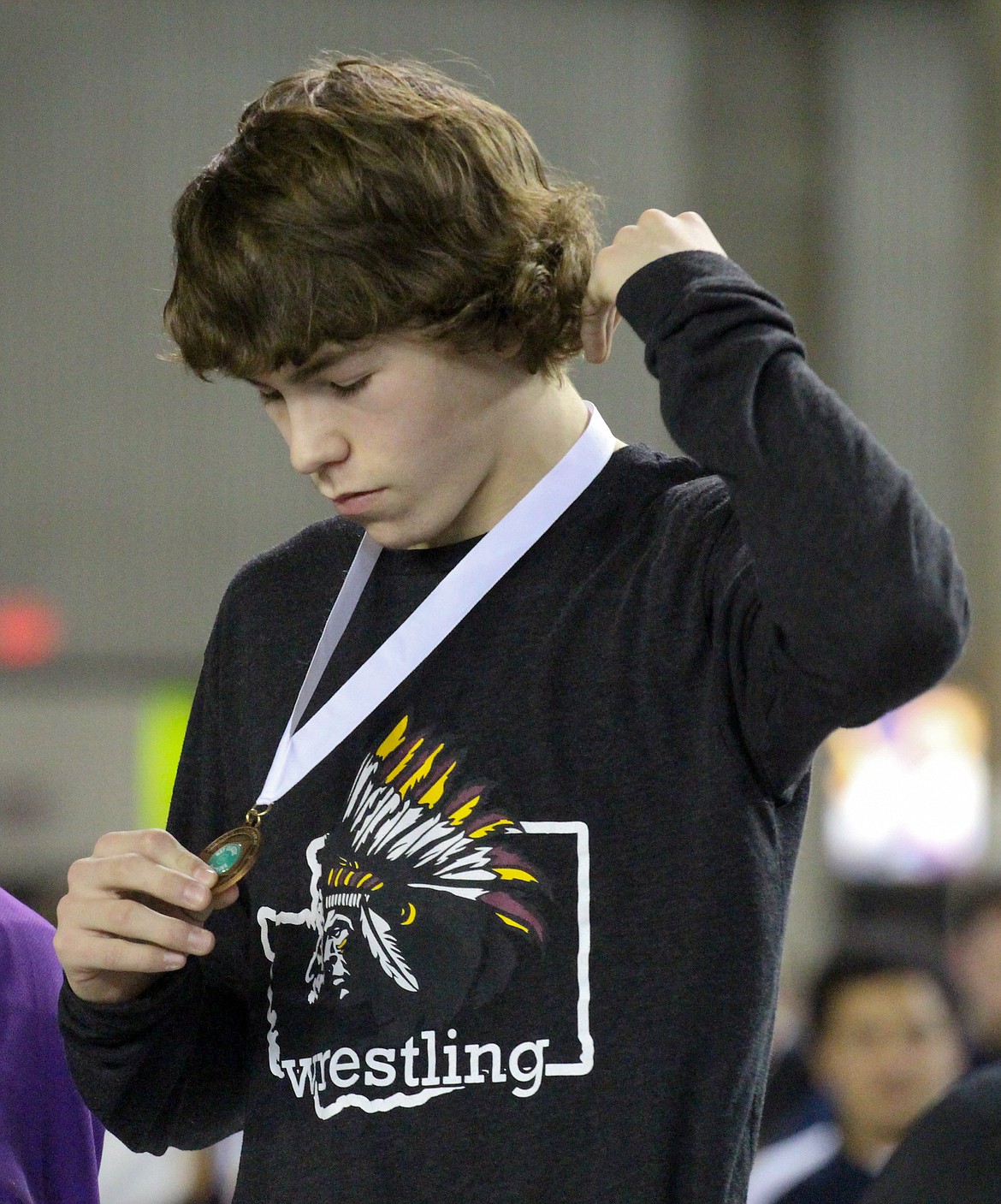 Casey McCarthy/Columbia Basin Herald Moses Lake's Hunter White accepts his fifth-place medal on Saturday at the Mat Classic in Tacoma.