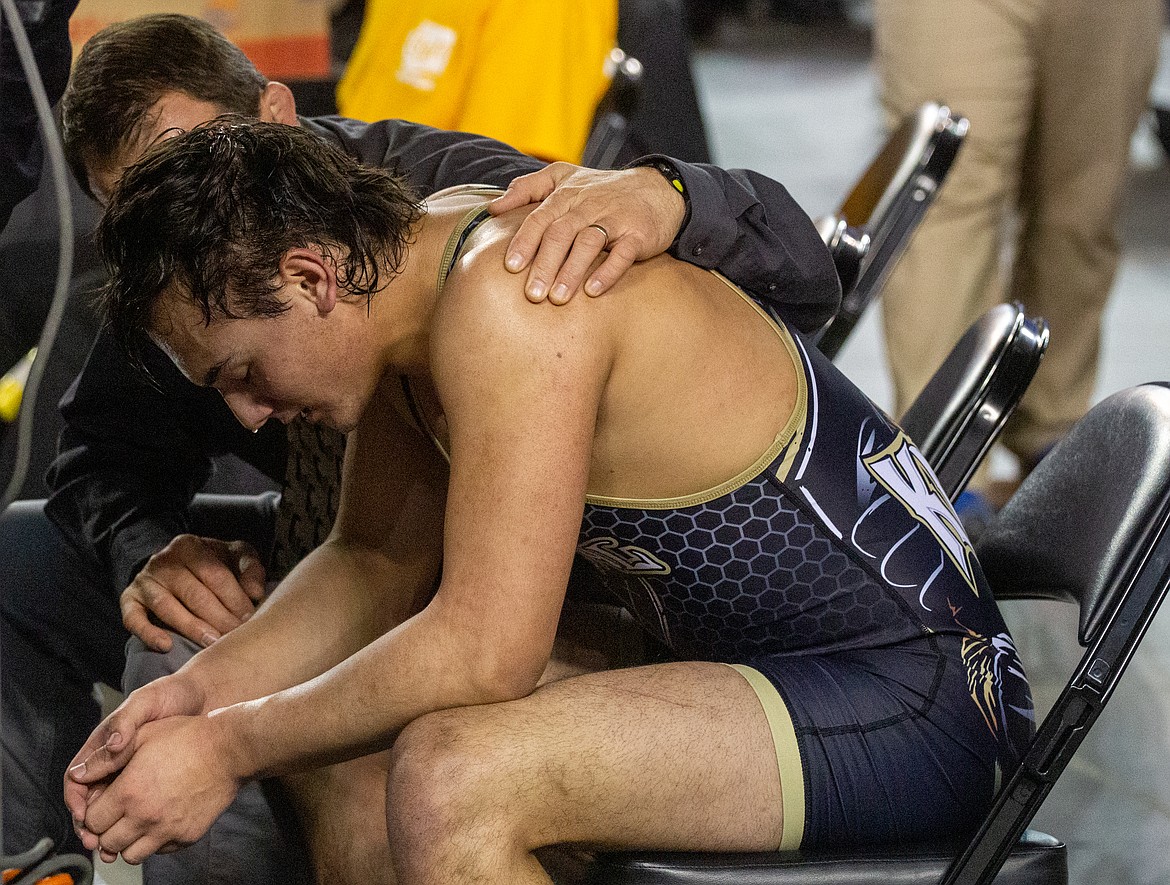 Casey McCarthy/Columbia Basin Herald Royal senior Lorenzo Myrick is comforted by his head coach, Ben Orth, after falling in the championship round to Granger's Diego Isordia on Saturday at the Mat Cl