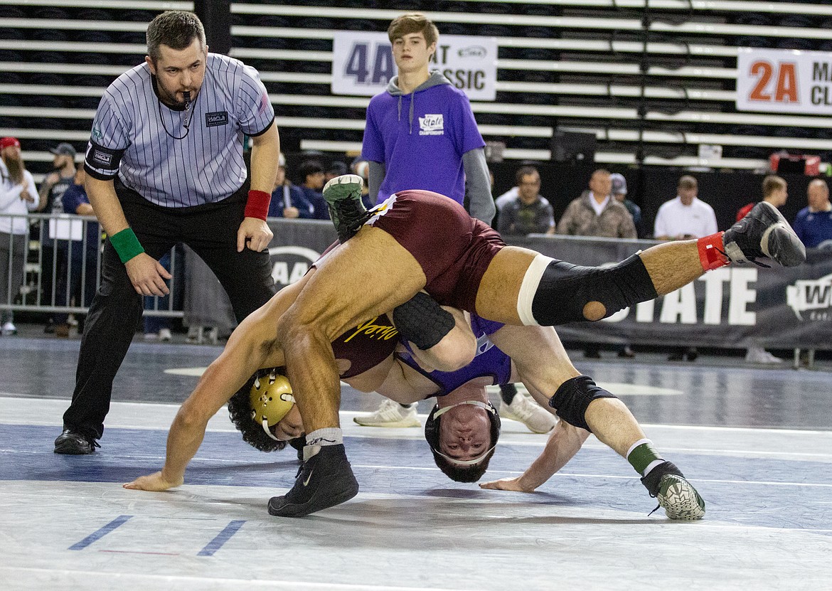 Casey McCarthy/Columbia Basin Herald Moses Lake's Cruz Vasquez and Heritage's Alex Newberry get tangled up as Vasquez takes his opponent to the ground in the third-place match at 160 pounds in 4A on 
