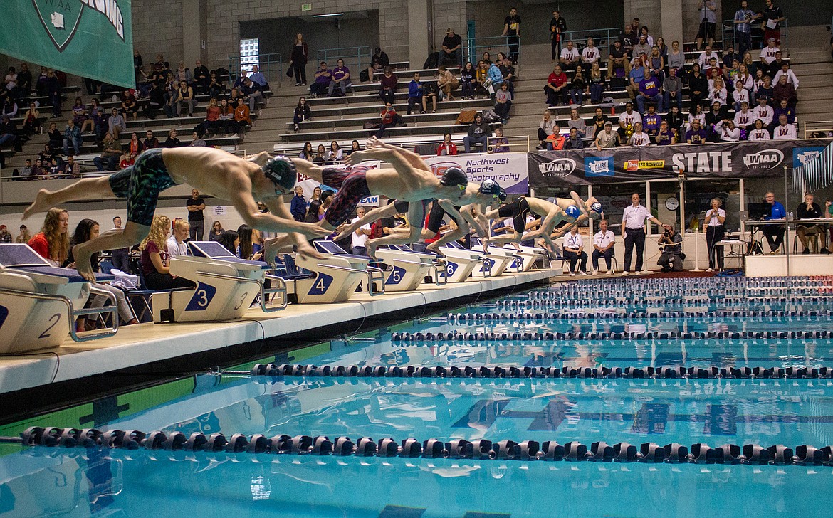 Casey McCarthy/Columbia Basin Herald Swimmers leave the block at the start of the 50-yard freestyle finals at the 4A state meet in Federal Way on Saturday.
