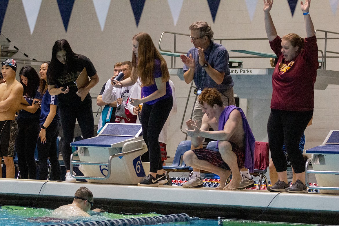 Casey McCarthy/Columbia Basin Herald Moses Lake assistant coach Linden Williams and senior Dylan Bond cheer on Jared Grant as he head into the finish of the unified 50-yard freestyle finals on Saturd