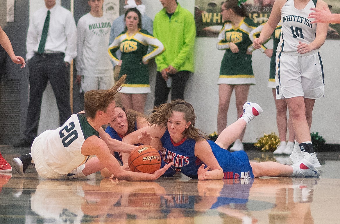 Lauren Falkner and Graceanne Sevesind fight for the loose ball against Whitefish last week. The girls held the Bulldogs to just 12 points.