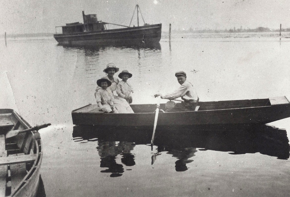 Jack Kehoe and family in fishing boat on Bigfork Bay with the SS-Helena in the background circa the early 1920s.