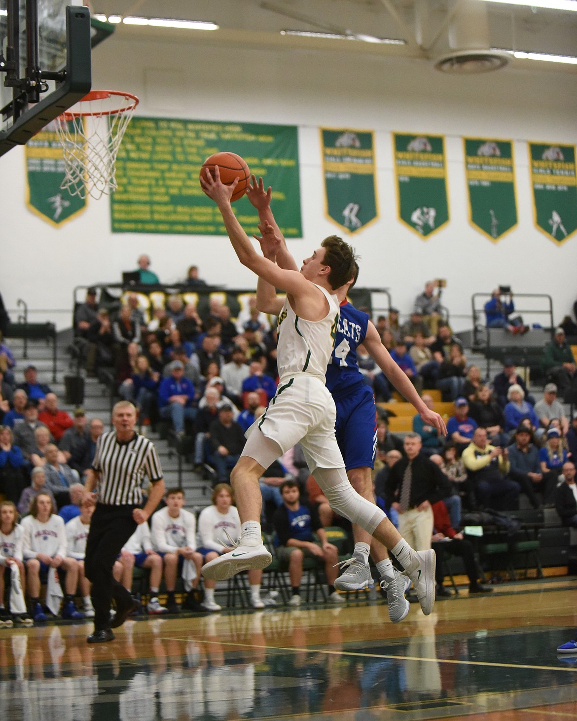 Bodie Smith skies for the layup during the Dogs’ Thursday night win over Columbia Falls. (Daniel McKay/Whitefish Pilot)