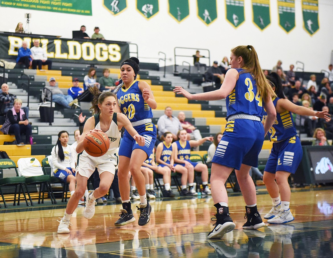 Erin Wilde looks to pass on the baseline during Monday’s play-in victory over Libby. (Daniel McKay/Whitefish Pilot)