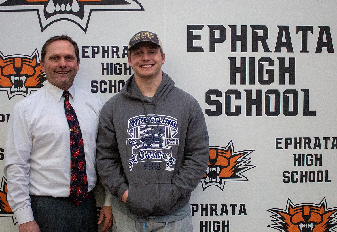 David Laird poses with his son, senior Mac Laird, at Ephrata High School. David was the first to congratulate Mac after walking off the mat in Tacoma as state champion on Saturday.